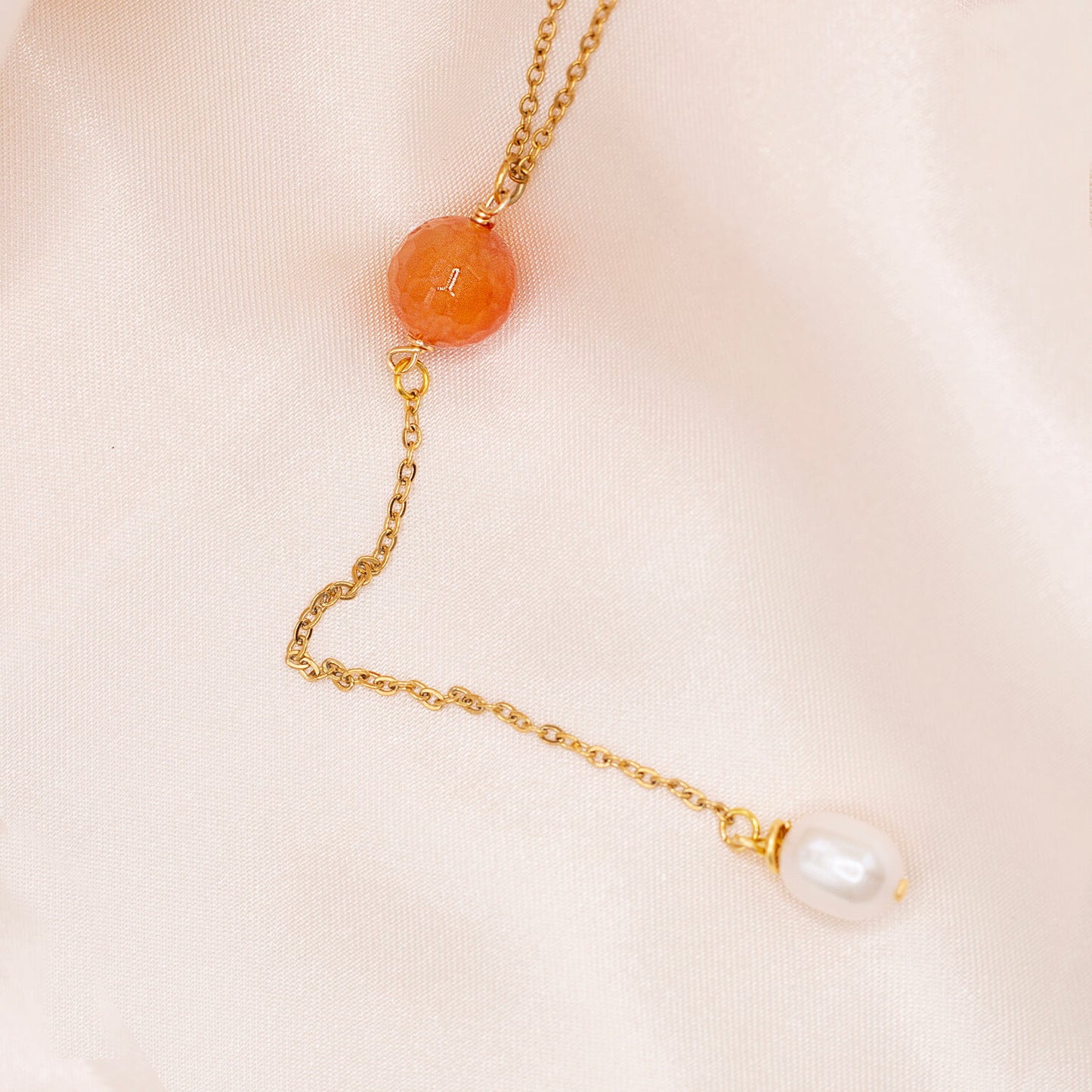 Orange red gemstone bead lariat necklace with dangling pearl. Hypoallergenic, gold-plated stainless steel. Water resistant.