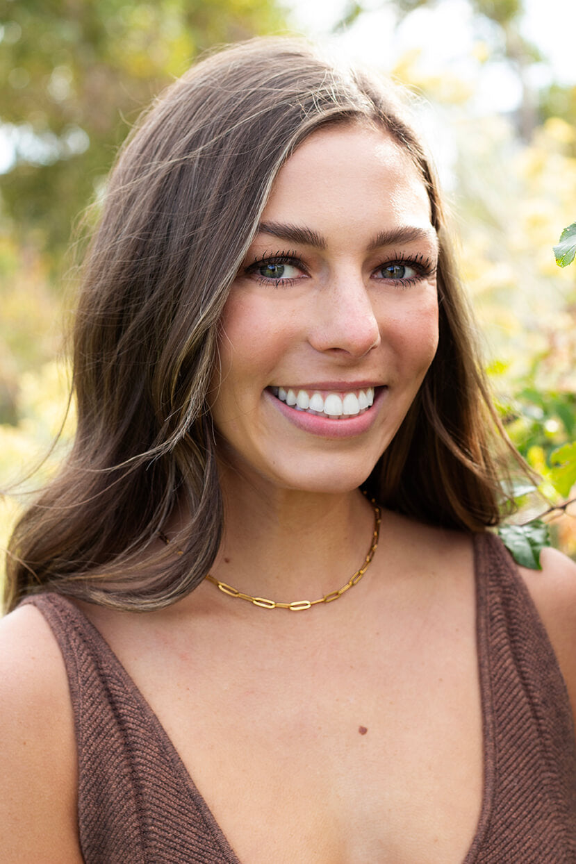 Beautiful woman wearing gold paperclip chain necklace